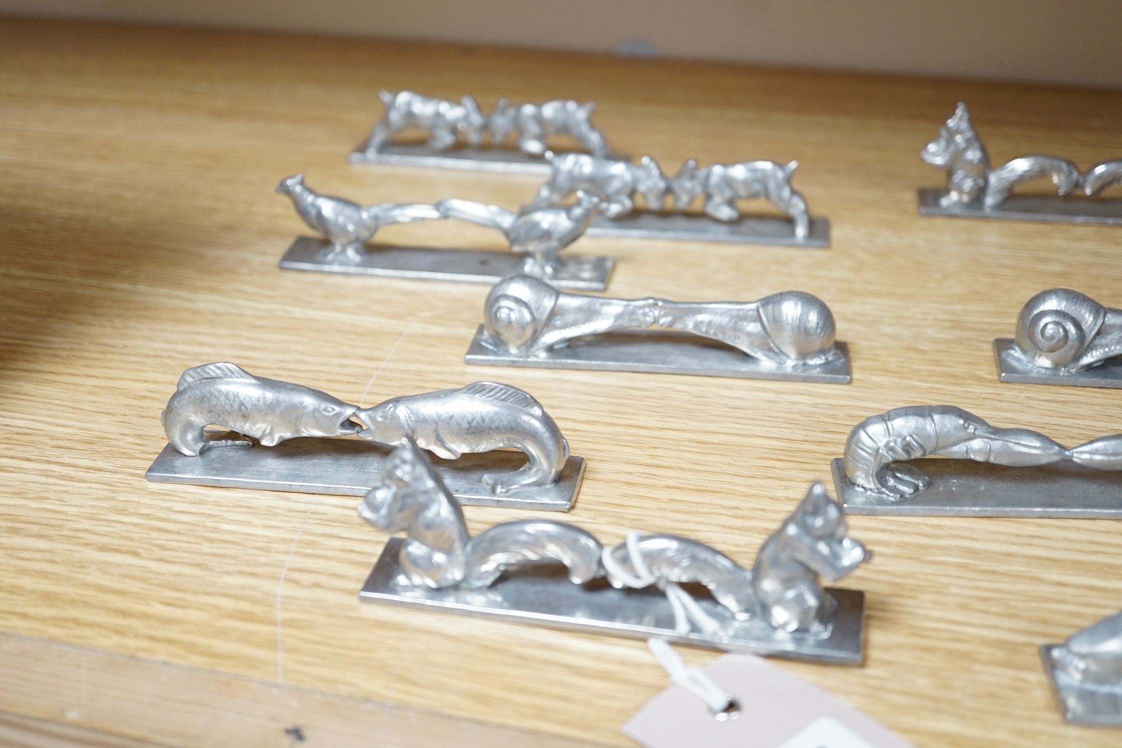 A set of 12 French pewter novelty knife rests, in the form of squirrels, fish, snails, goats, etc.